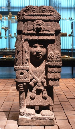 A statue of Aztec goddess Chicomecoatl holding pine cones