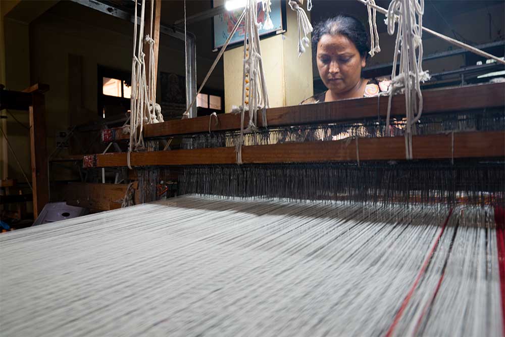 A weaver weaving a Kullu shawl