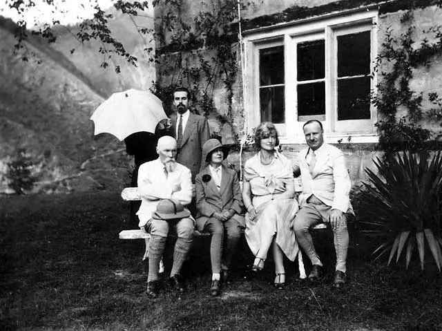 Nicholas Roerich with friends and wife Helena (holding umbrella) in front of their house in Naggar.