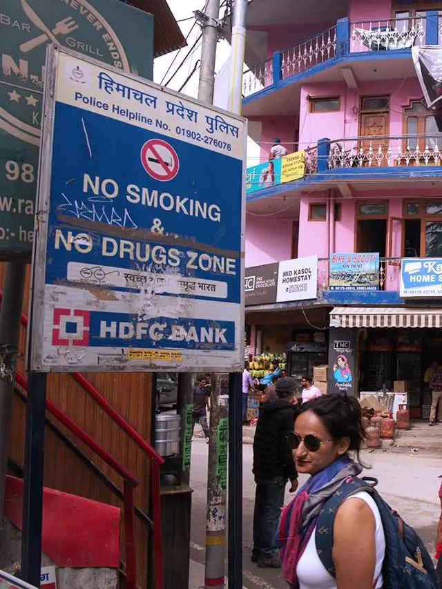 A woman standing in front of a signboard in Kasol