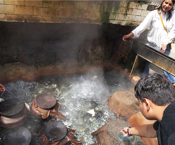 Pilgrims cooking rice in the hot boiling water in the Shiv temple of Manikaran 