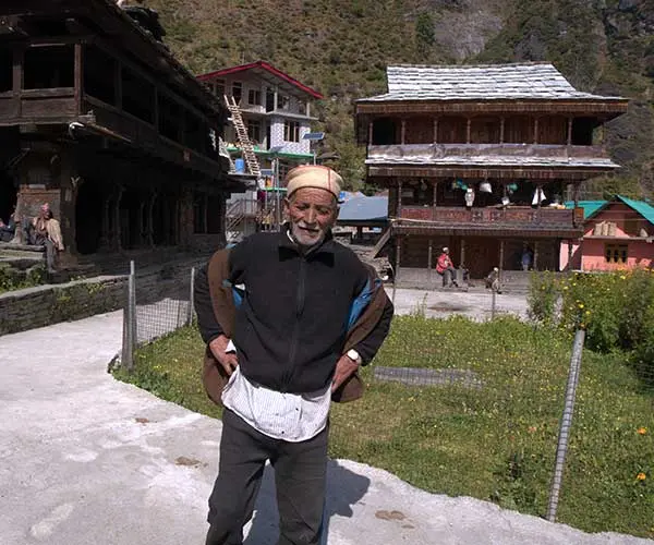 An elderly Malani in front of the temple of Jamlu deity.