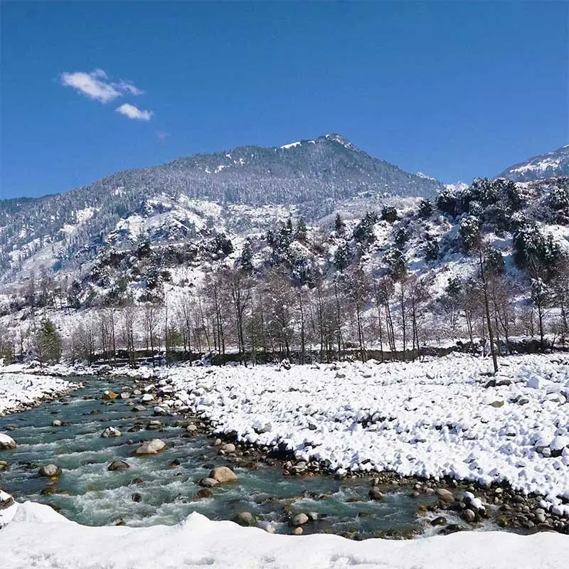 A snow-covered Manali with Beas river.